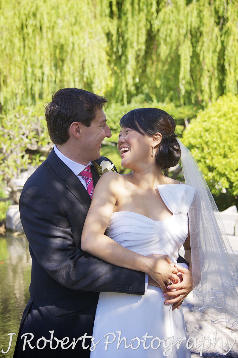 Bride and groom laughing at each other - chinese gardens sydney - wedding photography sydney